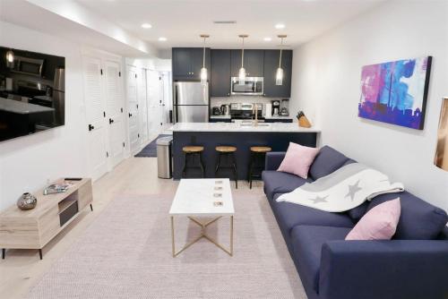 a living room with a blue couch and a kitchen at Slumber in Sophistication in Shaw-PKG in Washington, D.C.