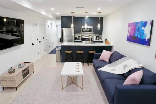 a living room with a blue couch and a kitchen at Slumber in Sophistication in Shaw-PKG in Washington, D.C.
