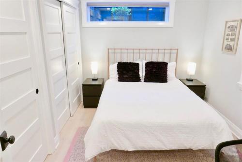 a bedroom with a white bed with two pillows at Slumber in Sophistication in Shaw-PKG in Washington, D.C.