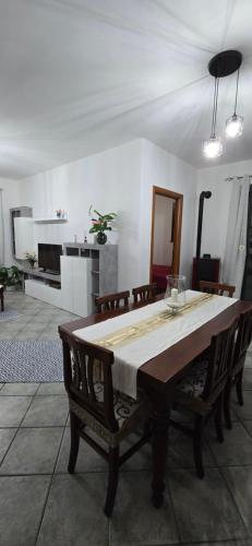 a dining room with a table with chairs and a kitchen at Bee House in Bosa
