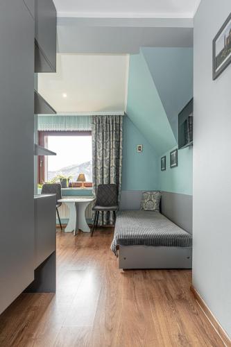 a living room with a bed and a table at Willa Jaś I Małgosia in Kościelisko