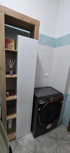 a small kitchen with a black microwave in a room at Bee House in Bosa