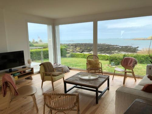 un salon avec vue sur l'océan dans l'établissement TY SUNSET Portsall, à Ploudalmézeau