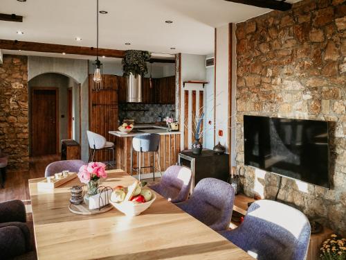 une cuisine et une salle à manger avec une table et des chaises en bois dans l'établissement къща за гости villa Jurta, à Avren