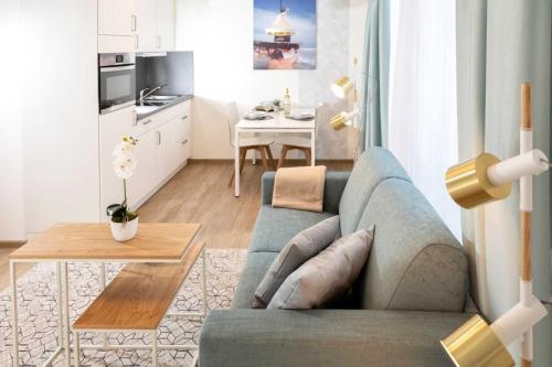 a living room with a blue couch and a kitchen at NINO-Boardinghouse 20 in Nordhorn