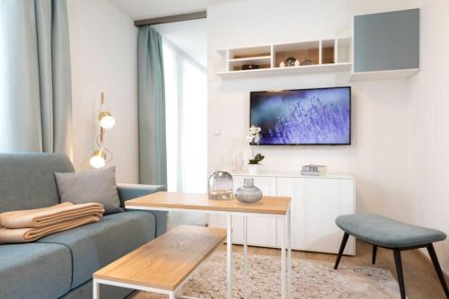 a living room with a blue couch and a table at NINO-Boardinghouse 20 in Nordhorn