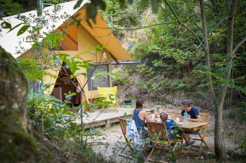 un groupe de personnes assises à une table devant une tente dans l'établissement Bivouac nature, Tentes Lodges dans les Cévennes, à Saint-Jean-du-Gard