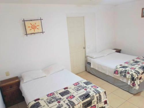 two beds in a room with white walls at Habitación Terraza 1 in Cocoyoc