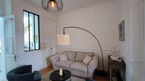 un salon avec un canapé et une lampe dans l'établissement Grande maison bourgeoise La Flèche, centre ville, à La Flèche