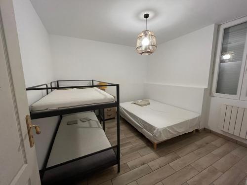 Cette petite chambre comprend deux lits superposés et une lampe. dans l'établissement La Petite Maison de la rue Fontaine Saint-Fursy, à Péronne