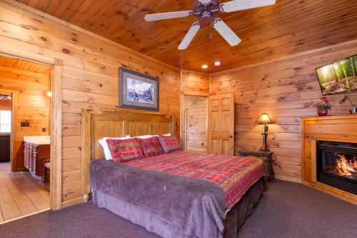 a bedroom with a bed in a room with a fireplace at The Great Escape II, 5 Bedrooms, Sleeps 17, Game Room, Pool Access, Theater in Gatlinburg