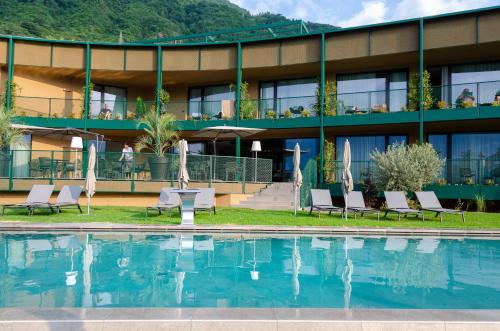 a hotel with a swimming pool in front of a building at VILLA NAJ in Termeno