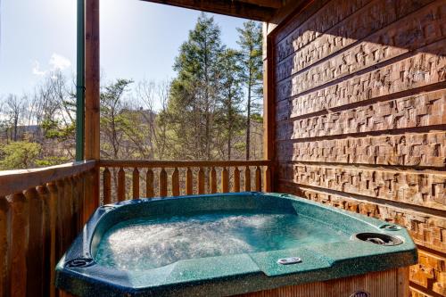 a jacuzzi tub on the back porch of a cabin at The Great Escape II, 5 Bedrooms, Sleeps 17, Game Room, Pool Access, Theater in Gatlinburg