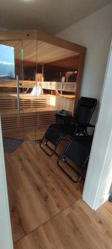 a living room with two chairs and a television at Landhaus Eifelliebe in Wallersheim