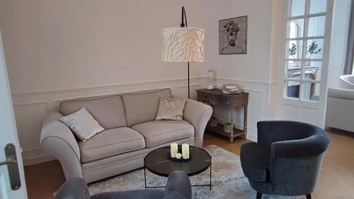 un salon avec un canapé, deux chaises et une table dans l'établissement Grande maison bourgeoise La Flèche, centre ville, à La Flèche