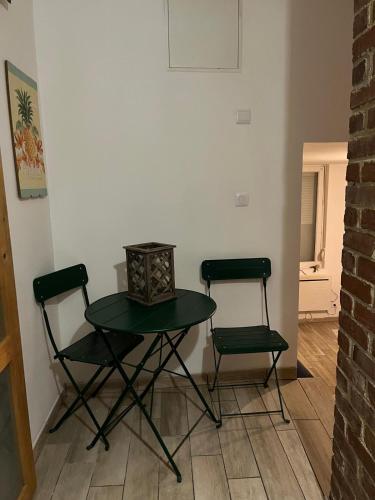 une table et deux chaises dans une pièce dans l'établissement La Petite Maison de la rue Fontaine Saint-Fursy, à Péronne