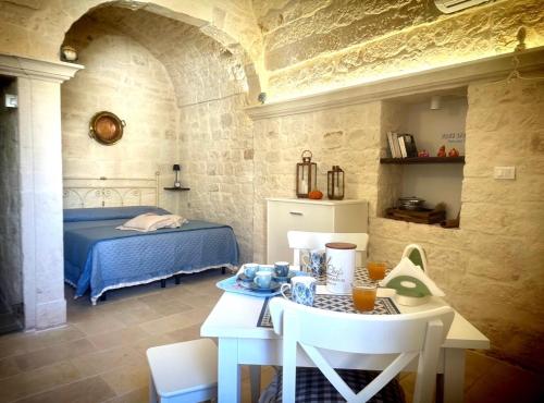 a bedroom with a bed and a table in a room at Suite LA PETRA in Ceglie Messapica