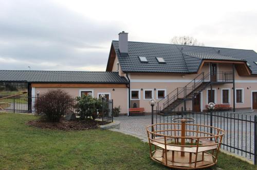 a house with a wrought iron fence in front of it at Penzion U Červené podkovy in Vlčkov