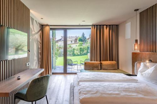 a hotel room with two beds and a large window at VILLA NAJ in Termeno