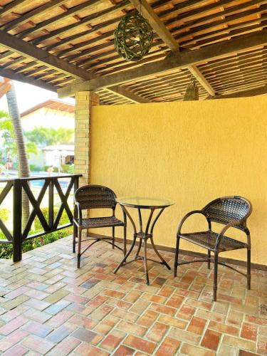 a patio with a table and two chairs and a table at Pousada Aconchego in Pitimbu