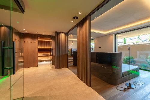 a living room with a large television and glass walls at VILLA NAJ in Termeno