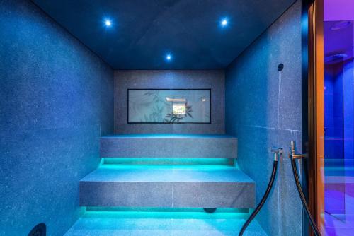 a blue bathroom with a shower with blue lighting at VILLA NAJ in Termeno