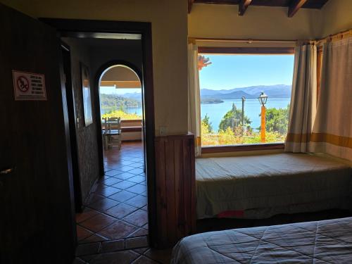 a bedroom with a bed and a large window at Brisas del Lago in San Carlos de Bariloche