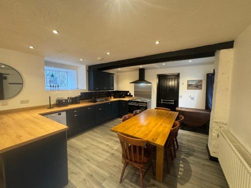 a kitchen with a wooden table and a dining room at Penrhyn Cottage in Penrhyn Bay