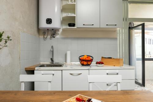 a kitchen with white cabinets and a bowl of fruit at Istra Central Corner in Pazin