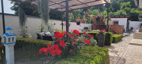 a garden with red flowers and a pavilion at Vila Jovana in Vrdnik
