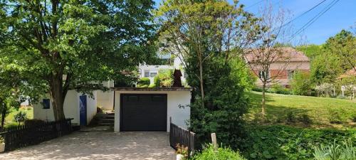 a garage in front of a house with a fence at Vila Jovana in Vrdnik