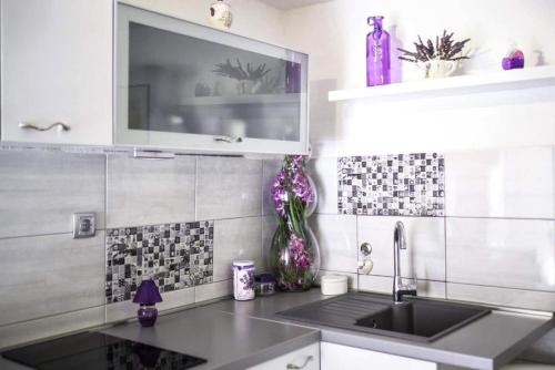 a kitchen with a sink and a tv on the wall at House Marie?s Lavander Dream in Raslina
