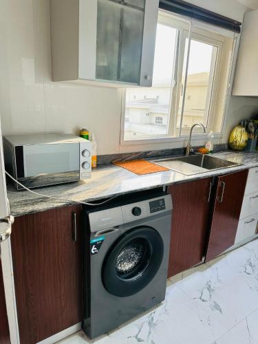 una cocina con lavadora y fregadero en QODE apartments, en Lekki