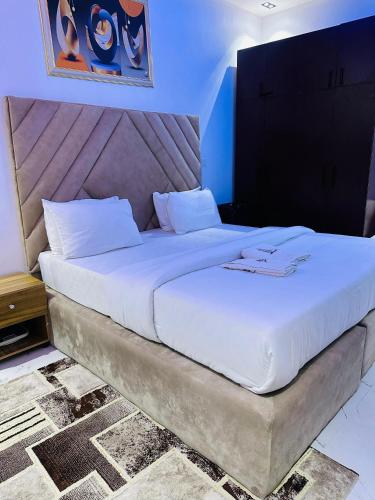 Un dormitorio con una cama grande con sábanas blancas. en QODE apartments, en Lekki