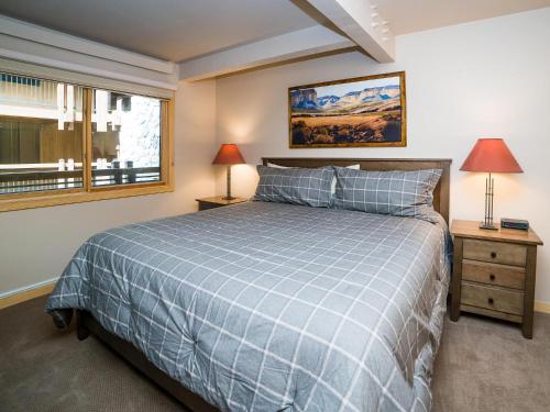a bedroom with a blue bed and a window at Lift One Condominiums - 1, 2, 3 Bedroom Units Adjacent To Downtown Aspen in Aspen