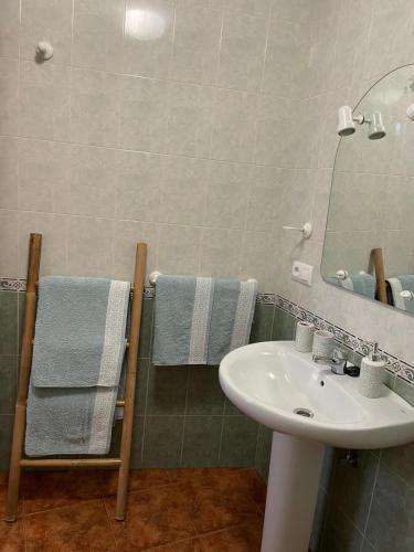 a bathroom with a sink and a mirror and towels at La torrecilla in Zuheros
