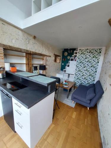 une cuisine avec un comptoir et une chaise bleue dans une pièce dans l'établissement Petite maison indépendante, à Briollay