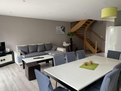 un salon avec un canapé, une table et des chaises dans l'établissement Villa Fétuque Crin d'Ours à Merlimont, à Merlimont