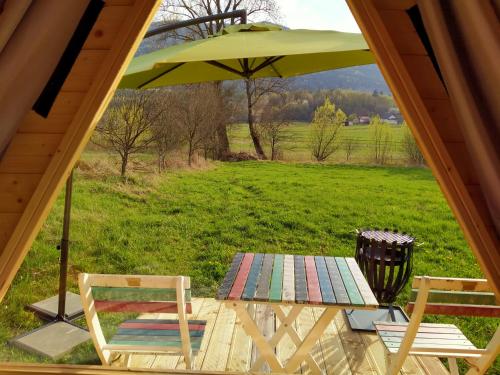 a picnic table with an umbrella and two chairs at Lika Sunset in Ličko Lešće