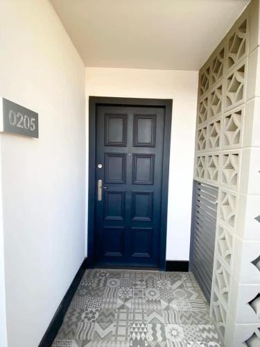 a blue door in a hallway with a tile floor at Dowtown 1 BR Suite in Av Revolucion Tijuana in Tijuana