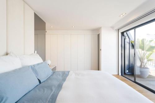 una camera da letto con un letto grande e una grande finestra di Luxury Suite With Balcony and Shared Accommodation in The Parque Eduardo VII Area a Lisbona