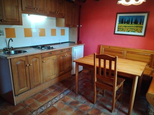a kitchen with a wooden table and a wooden chair at Casa Juez in Ascaso