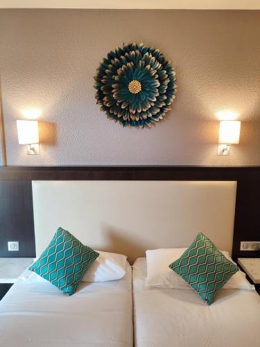 a hotel room with a bed and a mirror on the wall at Hôtel Le Collier in Antibes