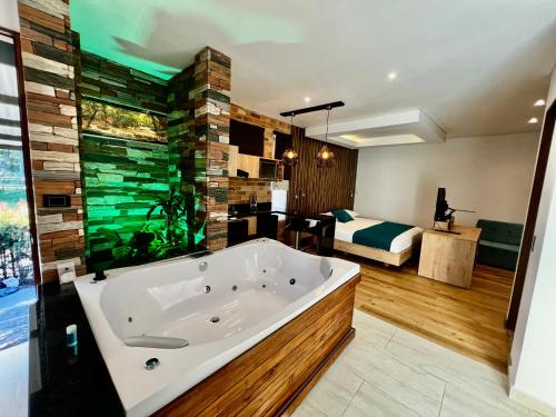 a large bathroom with a tub and a bedroom at Hotel Toscana Oriente in Rionegro
