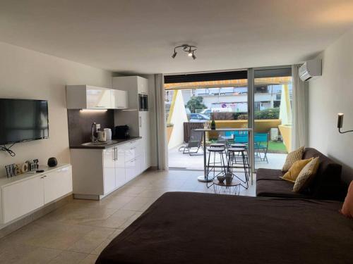 une cuisine et un salon avec un canapé et une table dans l'établissement Résidence Héliopolis Bâtiment D - studio 2 Pers. Héliopolis Bât. D MAE-4584, au Cap d'Agde
