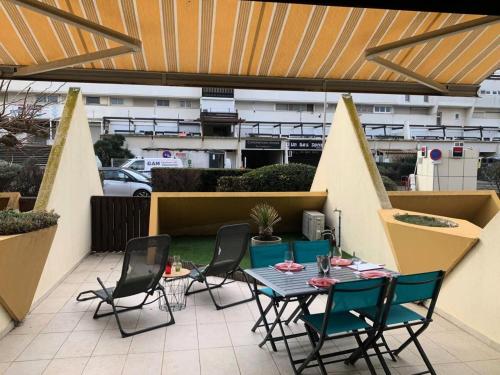 un patio avec une table et des chaises sur un balcon dans l'établissement Résidence Héliopolis Bâtiment D - studio 2 Pers. Héliopolis Bât. D MAE-4584, au Cap d'Agde