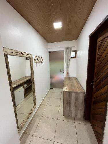 a dressing room with a mirror and a door at Pousada Aconchego in Pitimbu