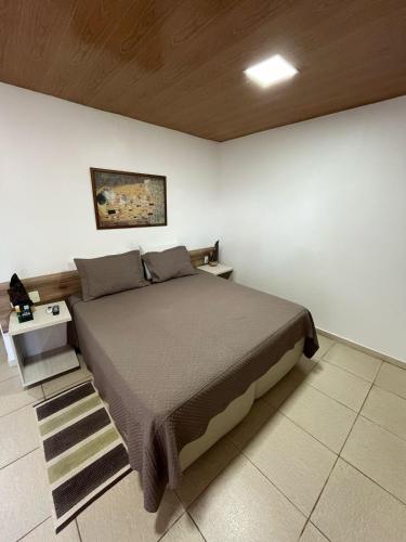 a bedroom with a bed in a white wall at Pousada Aconchego in Pitimbu