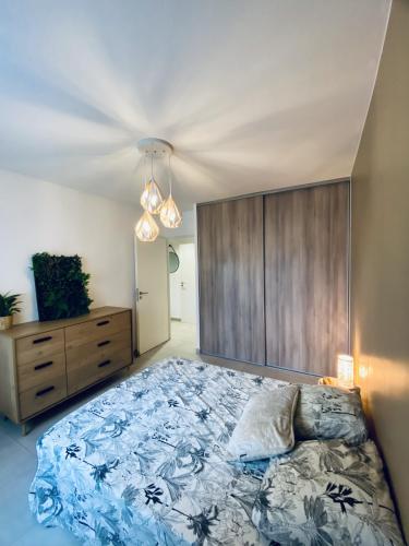- une chambre avec un grand lit et une tête de lit en bois dans l'établissement Cantosia - Appartement T3, Terrasse & Jardin Privatif, à Saint-Brès