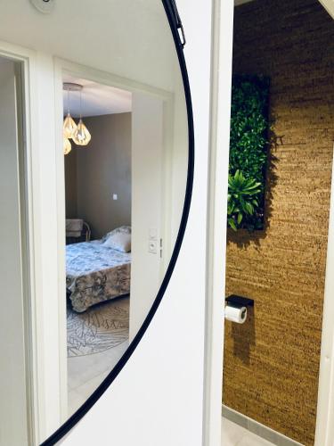 un miroir en face d'une chambre avec un lit dans l'établissement Cantosia - Appartement T3, Terrasse & Jardin Privatif, à Saint-Brès